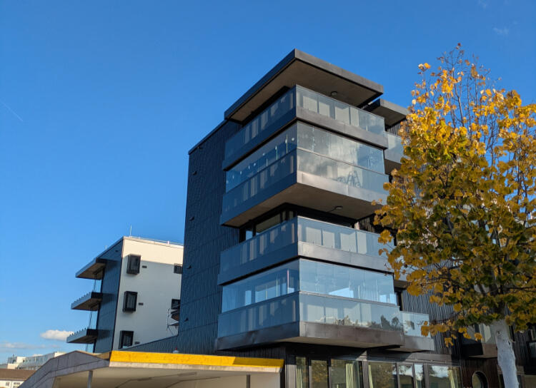 Balkonverglasungen an Mehrfamilienhaus Modernes Mehrfamilienhaus mit großflächigen Glasverkleidungen und verglasten Balkonen